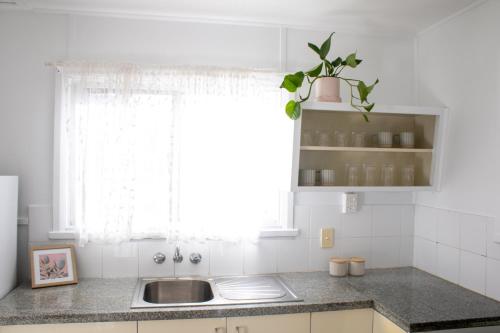 a kitchen with a sink and a window at CoastalandCo in Evans Head