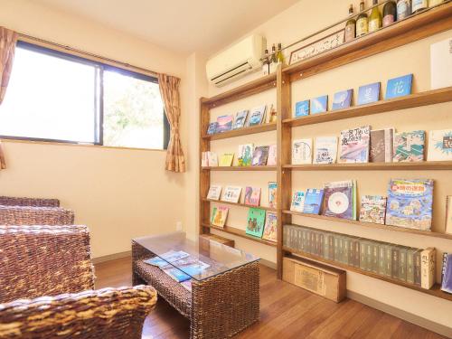 un soggiorno con librerie e un tavolo di 真砂悠々庵 a Minamichita