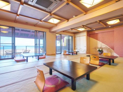 a room with a table and chairs and a large window at 真砂悠々庵 in Minamichita