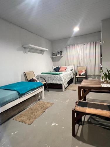 a room with two beds and a table at Chalé Praia Doce in Belém