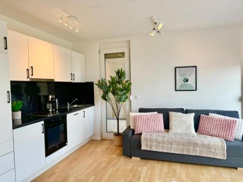 a living room with a couch and a kitchen at Modern Apartment with Balcony near Vienna in Wiener Neudorf