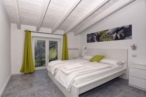 a white bedroom with a large bed and a window at Apartments in Tremosine sul Garda 34645 in Tremosine Sul Garda