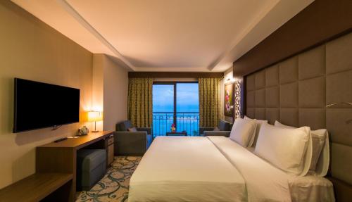 a hotel room with a bed and a flat screen tv at Radisson Blu Hotel, Ordu in Ordu