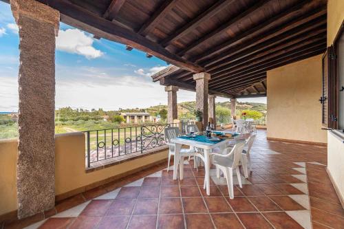 Un patio con una mesa y sillas en un balcón. en House and Apts. Siniscola - Sardinien 35758, en Santa Lucia