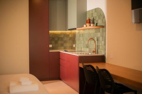 a kitchen with a sink and a table and chairs at The Alluna Motel, an Ascend Collection Hotel in Armidale