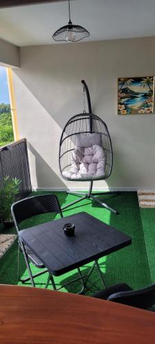 a room with a hammock and a table and chairs at Hedeun studio in Fort-de-France