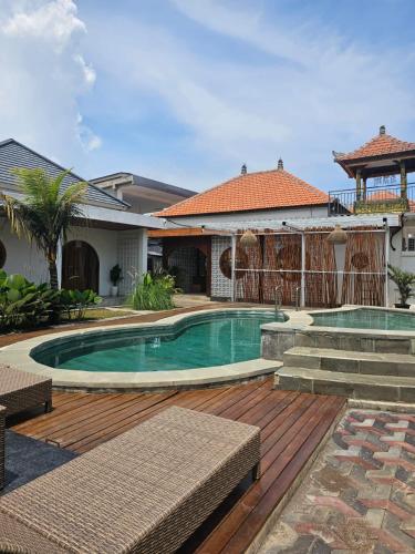 a swimming pool in a yard with a house at BBC Suites and Garden in Uluwatu