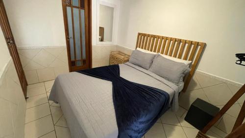 1 dormitorio pequeño con 1 cama con sábanas azules en Vilamaruá Chalé próximo da praia do Perequê, en Ilhabela