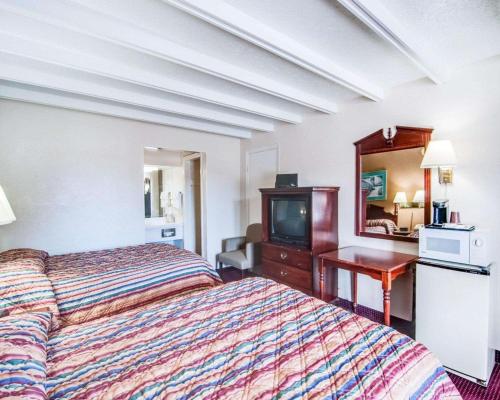 a hotel room with a bed and a television at Econo Lodge Galax in Galax