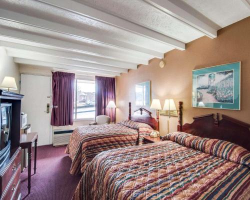 a hotel room with two beds and a television at Econo Lodge Galax in Galax