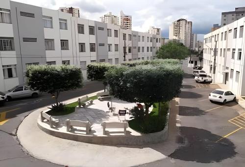 a courtyard with benches and trees in a city at SQ131A Moderno e Aconchegante in Goiânia