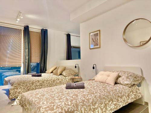 een slaapkamer met twee bedden en een spiegel bij Modern Apartment with Terrace Patio in Wiener Neudorf