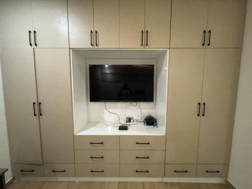 a white cabinet with a tv on top of it at Modern Serene 7-Guest Townhome in Trofwi