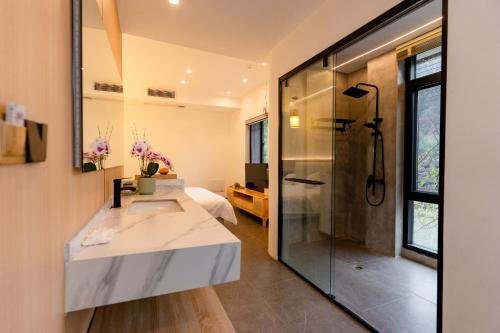 een badkamer met douche en wastafel bij Phoenix Mountain View Courtyard Homestay in Fenghuang