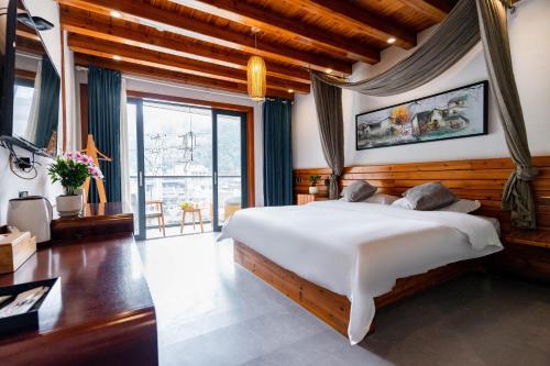 een slaapkamer met een groot bed en een groot raam bij Phoenix Mountain View Courtyard Homestay in Fenghuang