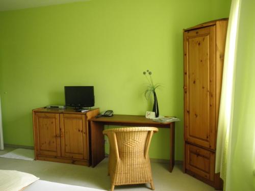 a room with a desk with a computer on a green wall at Herberts Stubn in Feldkirchen bei Graz