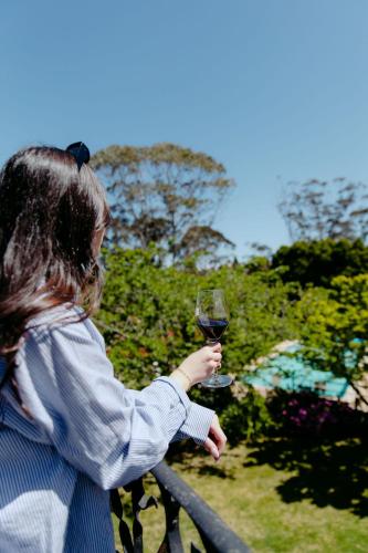 a woman holding a glass of red wine at Mountain Heritage Hotel in Katoomba