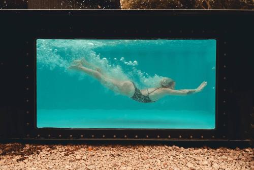 a person swimming in the water in the aquarium at Zen House 6 - Villas & Spa in Morin Heights