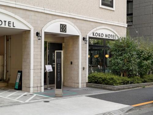 a building with two arches on the side of it at KOKO HOTEL Shimbashi Onarimon - formerly Hotel Wing International Shimbashi Onarimon in Tokyo