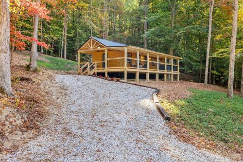 a house in the woods with a gravel driveway at Throw'n Shade at the Red - near RRG KY in Stanton