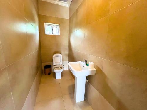 a bathroom with a sink and a toilet at Mar Luther Inn in Aburi