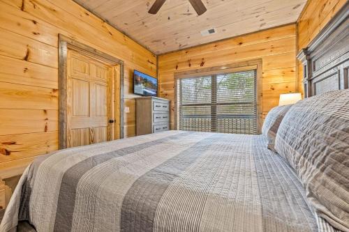 a bedroom with a bed in a wooden cabin at Pet-Friendly Sevierville Cabin, Hot Tub, Air Hock in Sevierville