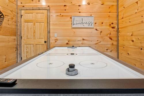 a pool table in a room with a wooden wall at Pet-Friendly Sevierville Cabin, Hot Tub, Air Hock in Sevierville