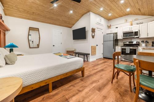 a bedroom with a large bed and a kitchen at Madeira Secluded Cottage 5-Min walk to Amphitheater, lighthouse, downtown in Saint Augustine