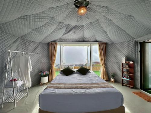 een slaapkamer met een groot bed in een tent bij ชาเลต์ ภูทับเบิก in Ban Maeo Thap Boek