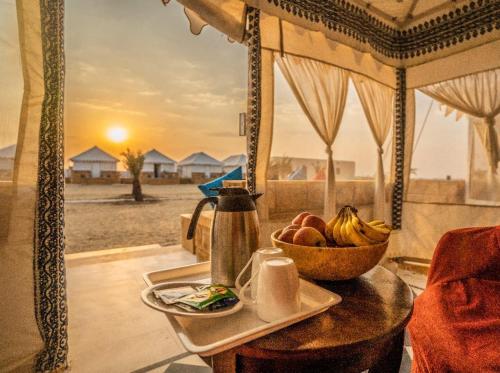 een tafel met een fruitschaal en een bord eten bij Desert Heritage Jaisalmer Camps & Resort in Jaisalmer