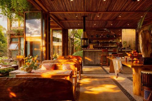 een woonkamer met banken, tafels en ramen bij Meilanmeilv Forest Luxe Inn-Chengdu Sansheng Township Branch in Ta-mien-chen