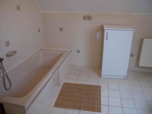 a bathroom with a tub and a small refrigerator at Holiday home Vonyarcvashegy - Balaton 31295 in Vonyarcvashegy