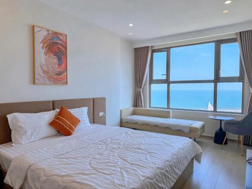 a bedroom with a bed and a large window at Ocean Pearl The Sóng Apartment - Vung Tau City - Căn Hộ View Biển, Hồ Bơi Vô Cực in Vung Tau