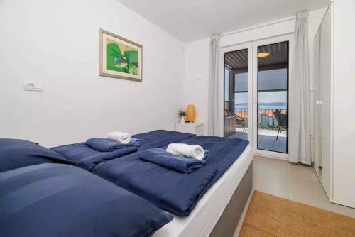 een bed met blauwe kussens in een kamer met een raam bij Holiday home in Selce 54575 in Selce