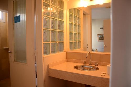 a bathroom with a sink and a mirror at Hotel Italia in Villa Carlos Paz