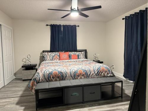 a bedroom with a bed with blue curtains and a ceiling fan at Serene Sunshine State Escape in Deltona