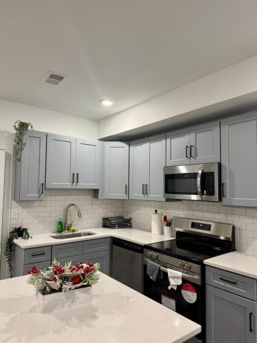 a kitchen with white cabinets and a counter top at Cozy Retreat Near EWR with NYC access in Newark