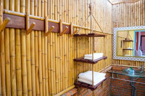 une salle de bains avec des murs en bambou, un miroir et des serviettes dans l'établissement Lumiere Family Village Đông Tác, à Hiếu Xương