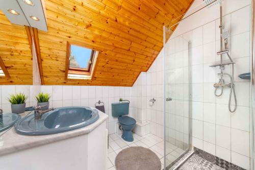 a bathroom with a blue tub and a toilet at Holiday home Balatonbereny - Balaton 18099 in Part