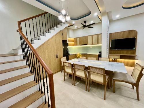 une salle à manger avec une table et des chaises et un escalier dans l'établissement Villa sát biển, 6pn, 9 giường, 7 toilet, hồ bơi riêng, bãi biển, sân vườn, à Tiến Thành