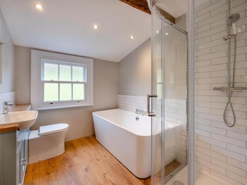 a white bathroom with a tub and a sink at 5 Bed in Threlkeld SZ270 in Threlkeld