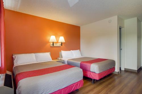 two beds in a hotel room with orange walls at Motel 6-Tacoma, WA - Fife in Fife