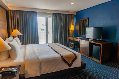 a hotel room with a bed and a television at Boracay Sands Hotel in Boracay
