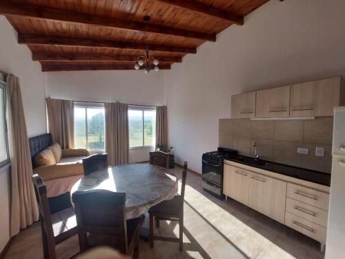 een keuken en eetkamer met een tafel en een bank bij Bosquemolinos in Villa Los Molinos