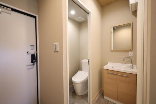 a bathroom with a toilet and a sink at NikkaHotel東郷店 in Togo