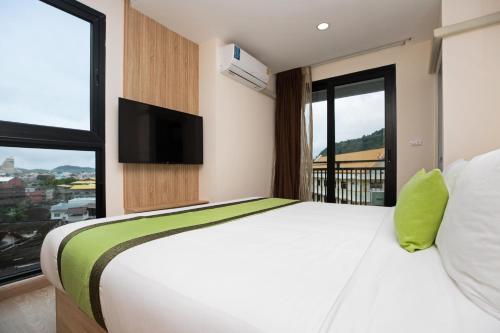 a bedroom with a large bed with a flat screen tv at iCheck inn Darisa Patong in Patong Beach