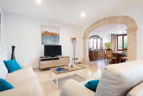 a living room with a couch and a tv at Cas Fraus in Sa Coma