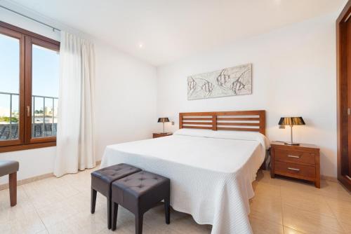 a bedroom with a large white bed and a window at Cas Fraus in Sa Coma