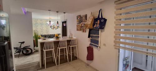 a kitchen with a bar and stools in a room at Modern & Comfortable Apartment in Aouina in El Aouina Station