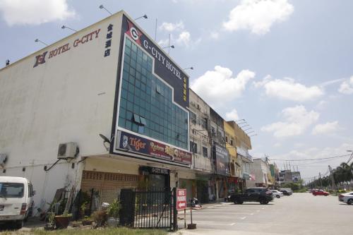Un edificio con un marcador electrónico al lado de una calle. en Gcity hotel, en Teluk Intan